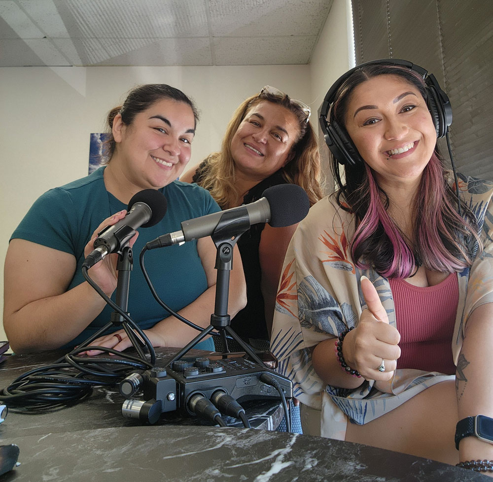 3 Voices 1 Path Podcast hosts smiling in the studio with microphones and headphones during a recording session